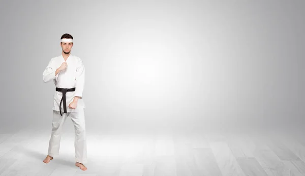 Karate-Trainer kämpft in einem leeren Raum — Stockfoto