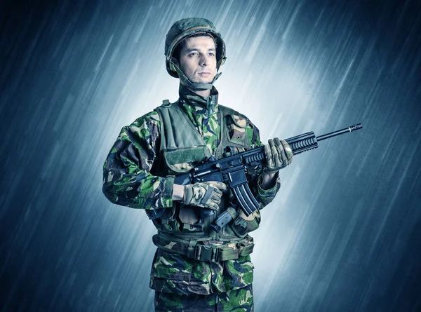 Armed soldier standing in rain — Stock Photo, Image