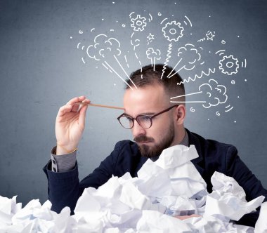 Genç işadamı buruşuk kağıt Dişliler ve Buhar çizimlerle başının üzerinde oturuyor.