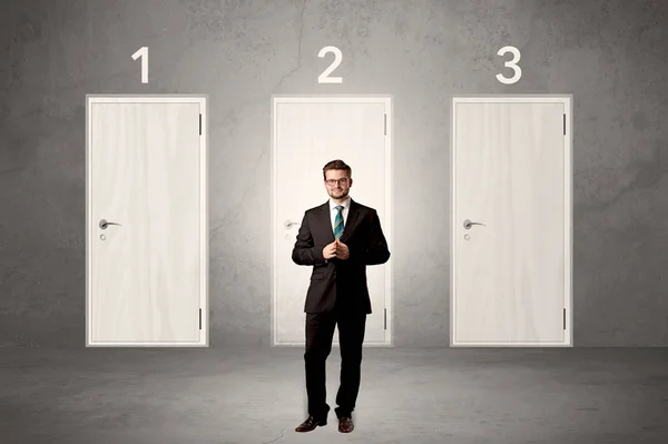 Businessman thinking in front of three doors — Stock Photo, Image
