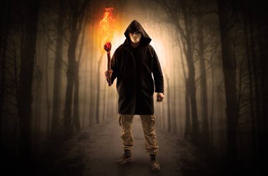 Adam flambeau onun el kavramında yanma ile karanlık ormandan gelen geliyor