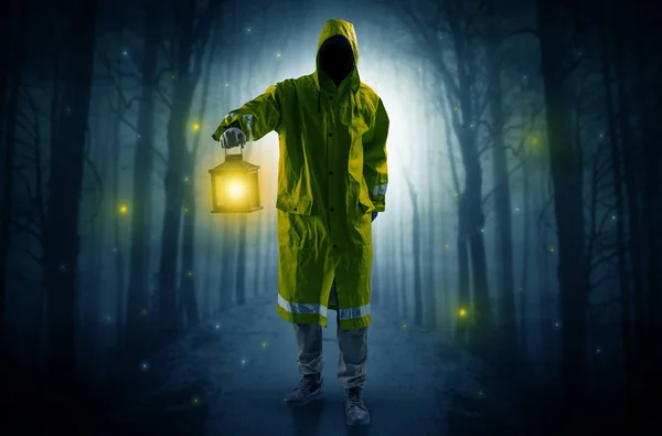 Mysterious man coming from a path in the forest with glowing lantern concept — Stock Photo, Image