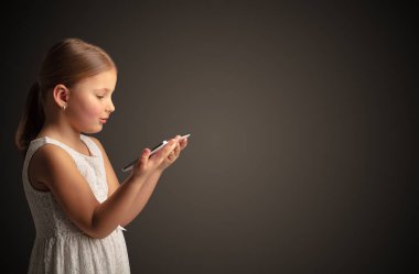 Tablet ile koyu arka plan kullanarak sevimli küçük kız