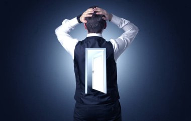 Ayakta ve sırtında bir açık kapı ile düşünme genç işadamı