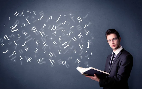 Young man holding book with letters — Stock Photo, Image