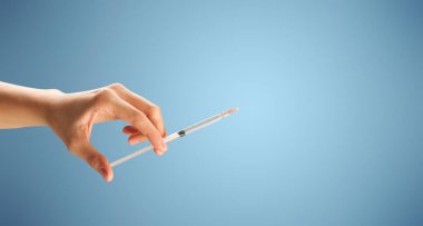 Kadın doktor elinde şırınga tutuyor.