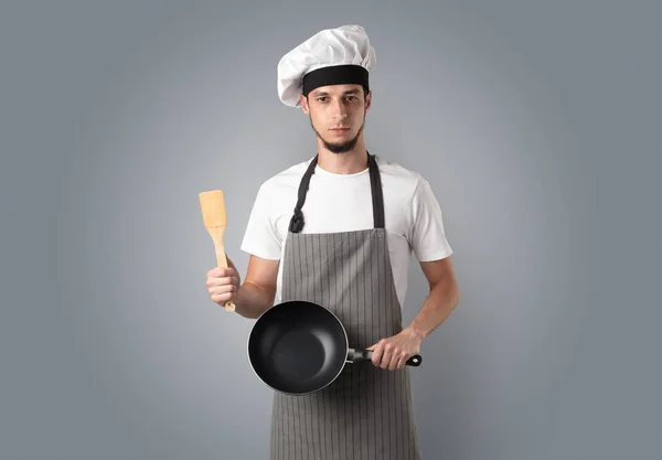 Cozinhe com ferramentas de cozinha e papel de parede vazio — Fotografia de Stock