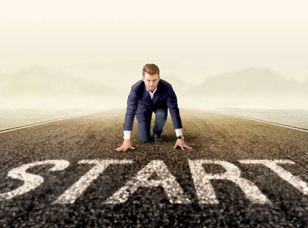 Genç işadamı bir başlangıç satırında diz çökmüş tespit 