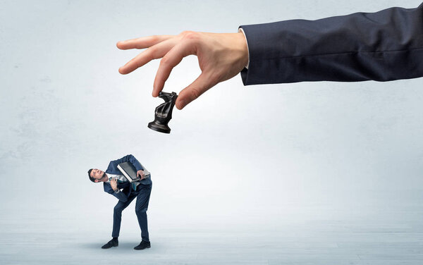 Большая рука с шахматистом вниз небольшой слабой концепции бизнесмена
