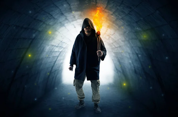 Man promenader med brinnande flambeau i en mörk tunnel — Stockfoto