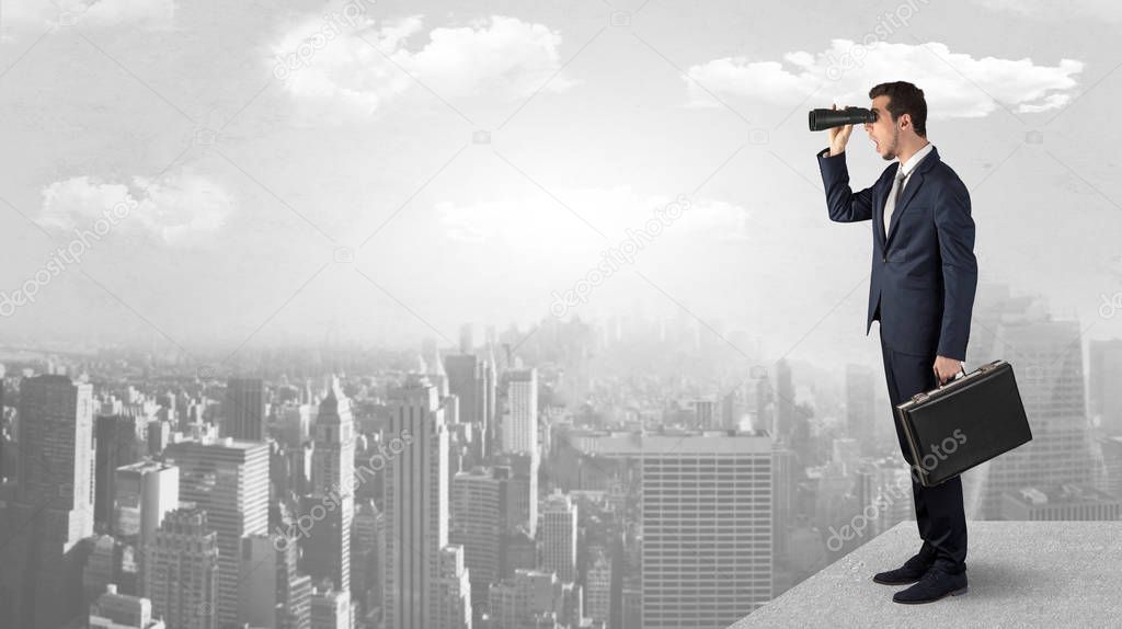 Man looking forward from the top of a skyscraper