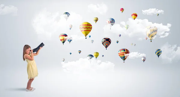 Niño mirando a través de spyglass a globos de aire — Foto de Stock