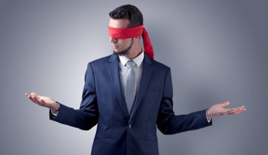 Kapalı göz işadamı bir duvarın önünde