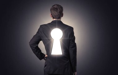 Sırtında siyah anahtar deliği ile ayakta adam