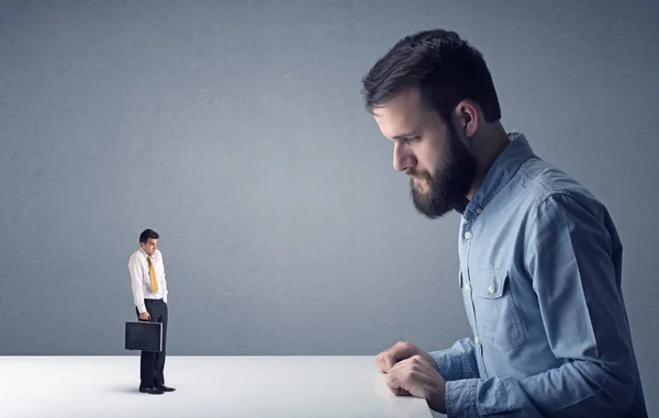 Joven hombre de negocios luchando con empresario en miniatura — Foto de Stock