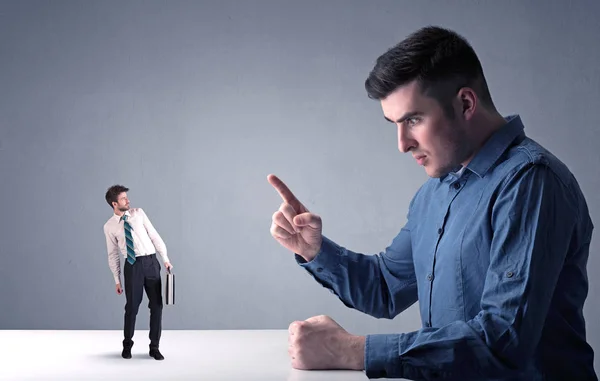 Young businessman fighting with miniature businessman — Stock Photo, Image