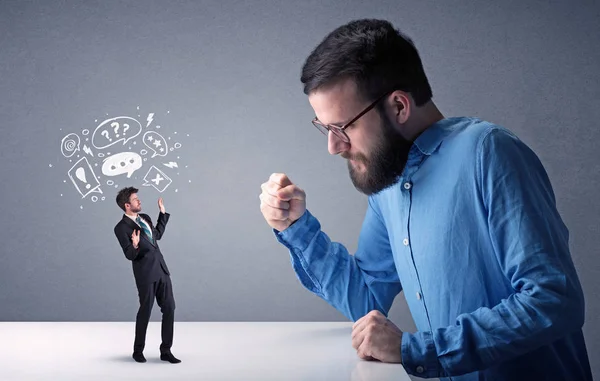 Young businessman fighting with miniature businessman — Stock Photo, Image