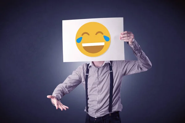 Empresario sosteniendo papel con emoticono risueño —  Fotos de Stock