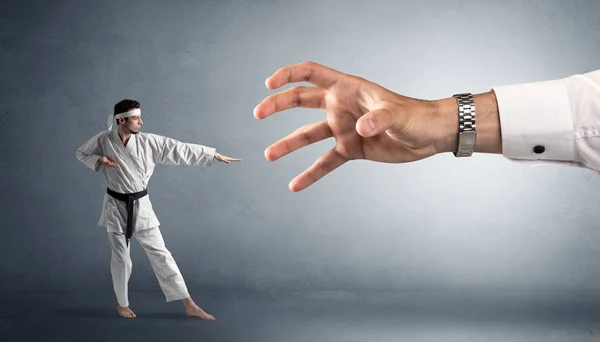 Stor hand fånga små karate man — Stockfoto