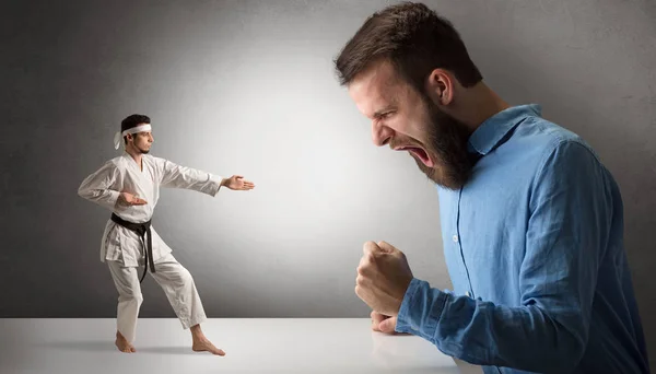 Riesenmann brüllt einen kleinen Karate-Mann an — Stockfoto