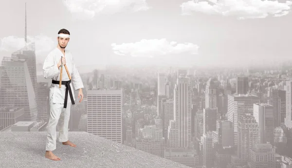 Karate man doing karate tricks  on the top of a metropolitan city