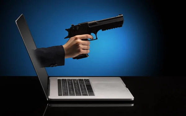 Hand met pistool coming out van een laptop — Stockfoto