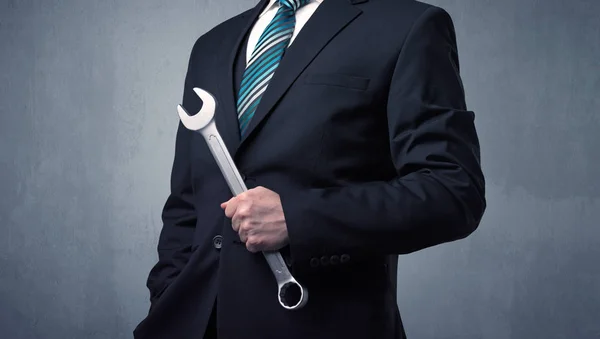 Бизнесмен стоит с инструментом на руке — стоковое фото