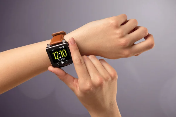 Female hand wearing and pressing smartwatch — Stock Photo, Image