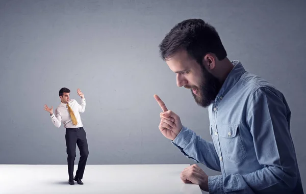 Young businessman fighting with miniature businessman — Stock Photo, Image