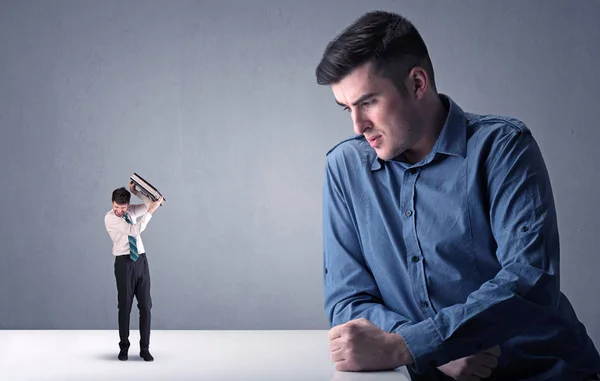 Young businessman fighting with miniature businessman — Stock Photo, Image