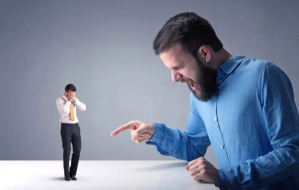 Young businessman fighting with miniature businessman — Stock Photo, Image