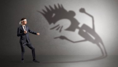 Karate man fighting with a big scary shadow clipart