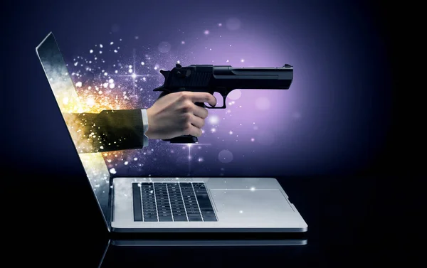 Hand with gun coming out of a laptop — Stock Photo, Image