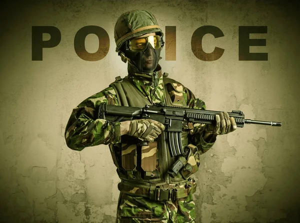 Ozbrojený voják s poškozenou zeď na pozadí — Stock fotografie