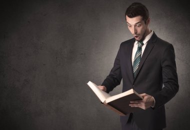 Elinde kitap tutan bir işadamı.
