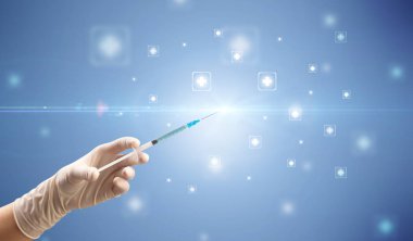 Kadın doktor elinde şırınga tutuyor.