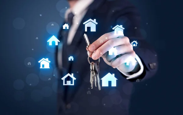 Geschäftsmann hält Schlüssel mit Häusern herum — Stockfoto