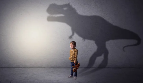 Dinosaure ombre derrière mignon garçon — Photo