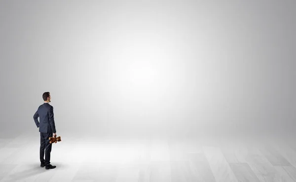 Man med objekt i sin hand i ett tomt utrymme — Stockfoto