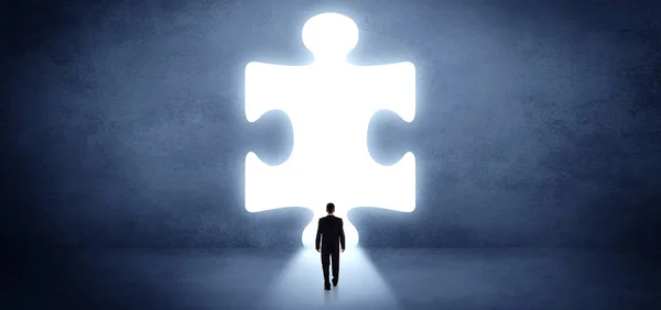 Businessman standing in front of a big puzzle piece — Stock Photo, Image