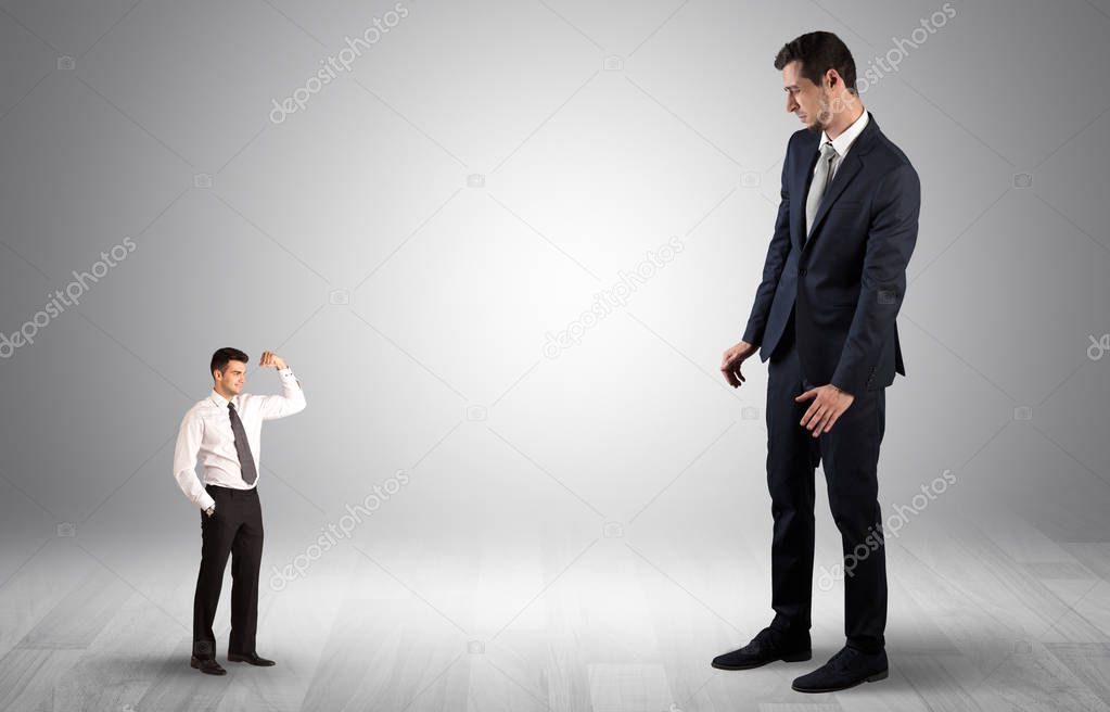 Big debutant young businessman scared of small strong businessman