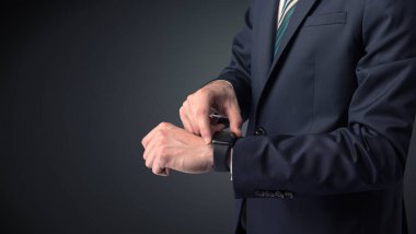 Smartwatch giyen takım elbiseli adam.