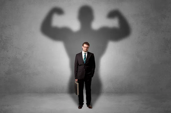 Businessman with muscular shade behind his back — Stock Photo, Image