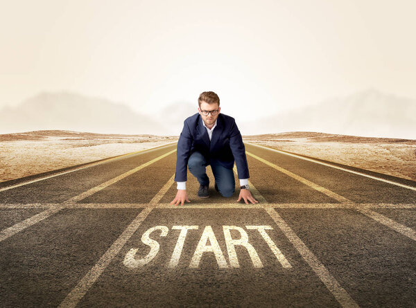 Бизнесмен на коленях в готовом положении
