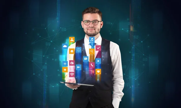 Man holding tablet with hologram app icons above