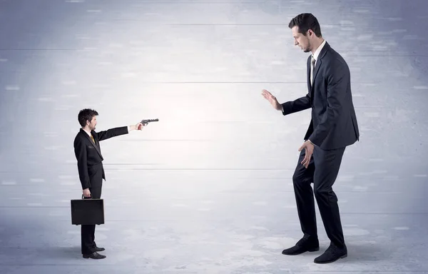 Pequeno homem de negócios atirando gigante empresário — Fotografia de Stock