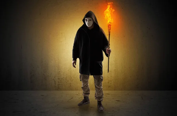 Man walking in an empty space with burning flambeau — Stock Photo, Image