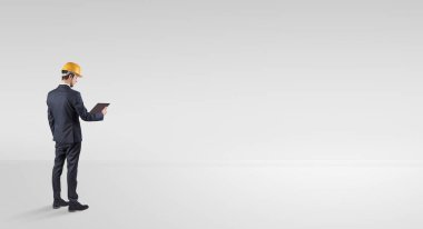 Boş bir alanda duran ve bir plan tutan mimar