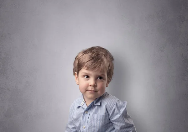 Menino adorável na frente de uma parede vazia — Fotografia de Stock