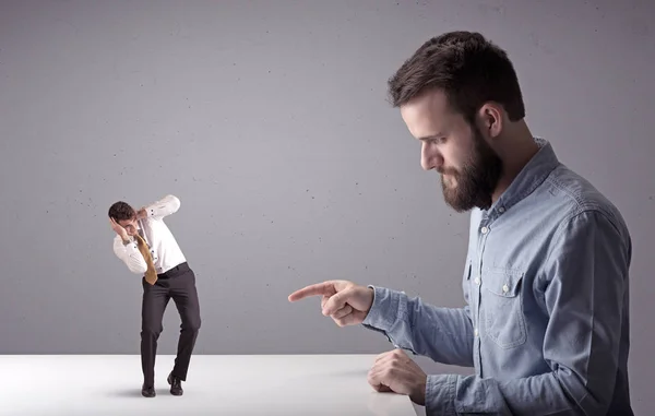 Joven hombre de negocios luchando con empresario en miniatura —  Fotos de Stock